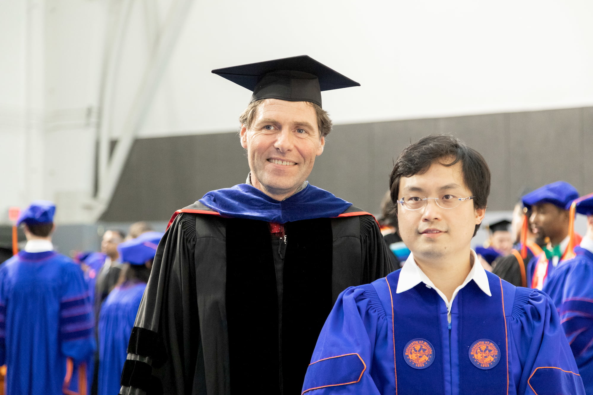 A professor and a student in graduation regalia